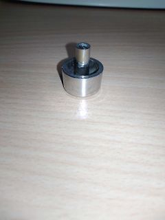 Metallischer Zylinder auf Holztisch