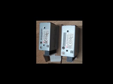 Zwei metallische Netzteile auf Holzuntergrund
