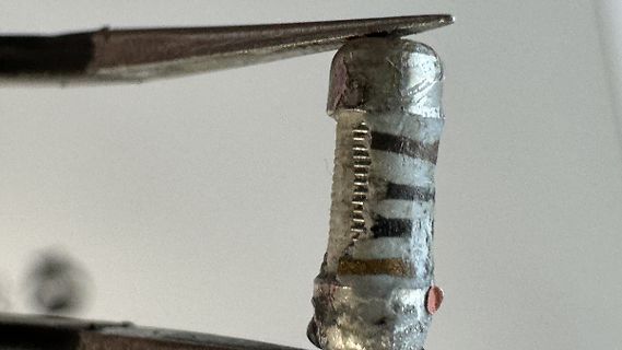 Makroaufnahme eines Bauteils mit Pinzette