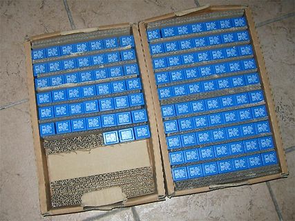 Zahlreiche blaue Bauteile in einem Karton