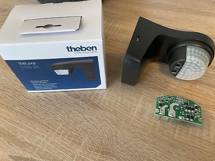Verpackung, Bewegungsmelder und Platine auf Holztisch
