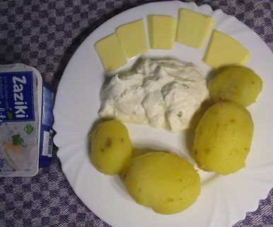 Kartoffeln mit Käse und Zaziki auf einem Teller