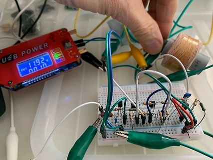 Elektronik-Aufbau mit Breadboard, Netzteil und Spule