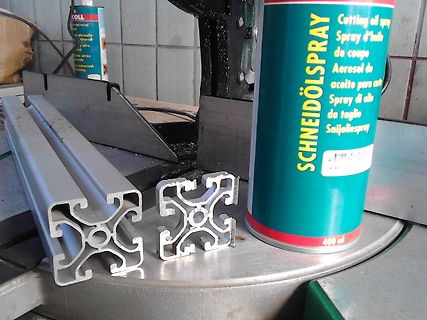 Aluminiumprofile und Schneidöl-Spray auf Werkstattuntergrund