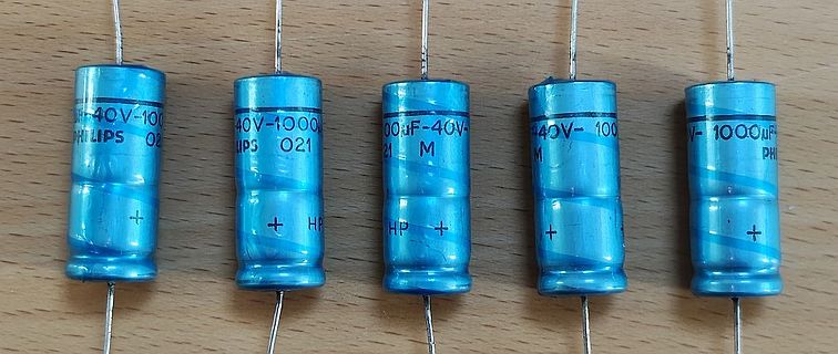 Fünf Elektrolytkondensatoren auf Holzuntergrund