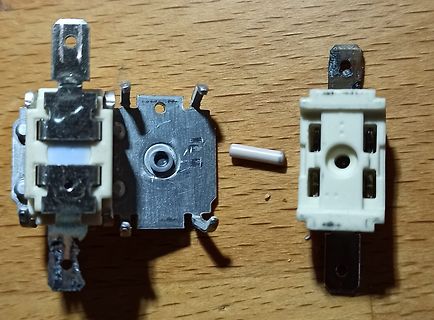 Zerlegte elektrische Schalterkomponenten auf Holzuntergrund