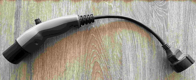 Netzteil-Stecker mit Kabel auf Holzuntergrund