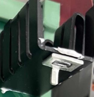 Nahaufnahme eines schwarzen Kunststoffprofils mit Metallklammer