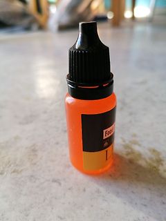 Orangefarbene Flasche mit schwarzem Deckel