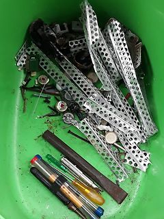 Schrottbehälter mit Metallteilen und Werkzeugen