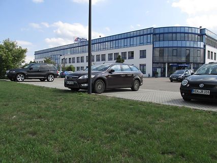 Parkplatz vor einem Firmengebäude mit Autos