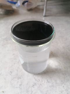 Becherglas mit dunkler Flüssigkeit