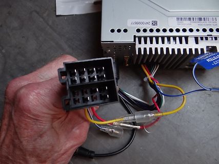 Hand hält Stecker vor Elektronikgerät
