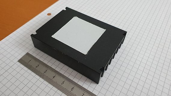 Schwarzer Kühlkörper mit Lineal auf Millimeterpapier