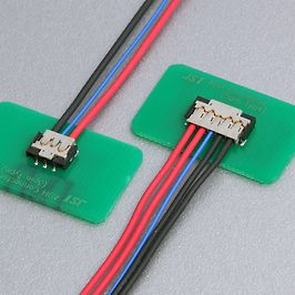 Zwei JST-Stecker mit Kabeln auf grünen Platinen