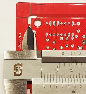 Messung einer Leiterplatte mit einem Messschieber