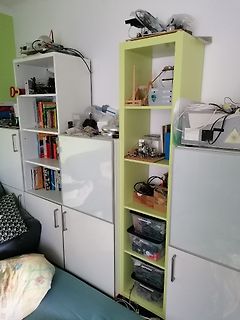 Unordnung in einer Werkstatt mit Regalen und Elektronikkomponenten