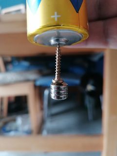 Batterie mit angeschlossener Feder und Metallobjekt