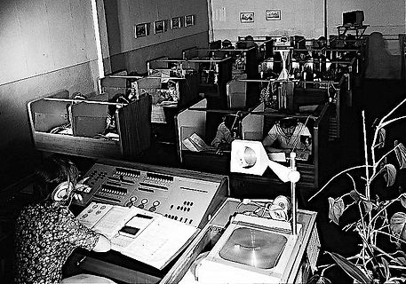 Büro mit Schreibmaschinen und einer Person im Vordergrund