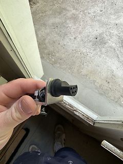 Hand hält elektrischen Stecker