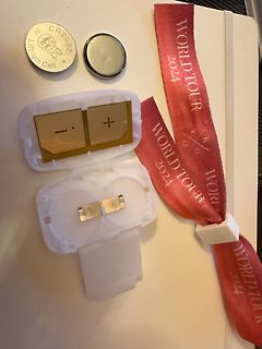 Knopfzellen und Batteriefach mit pinkem Band