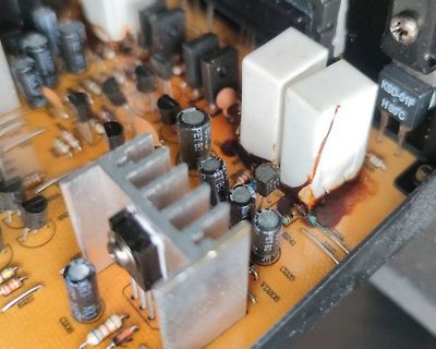 Nahaufnahme einer beschädigten Leiterplatte mit Elektrolytkondensatoren