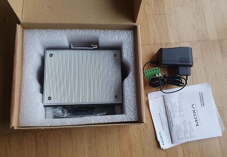 Moxa Gerät in Verpackung mit Netzteil und Anleitung