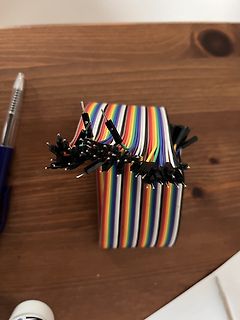 Buntes Flachbandkabel mit Steckverbindern auf Holztisch