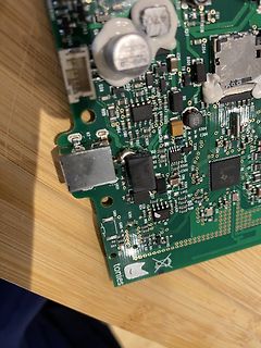 Nahaufnahme einer grünen Leiterplatte mit elektronischen Bauteilen