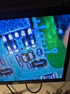 Abfotografierte mikroskopische Aufnahme einer Leiterplatte auf einem Monitor