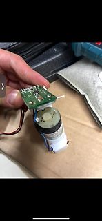 Hand hält Elektromotor mit angeschlossener Platine