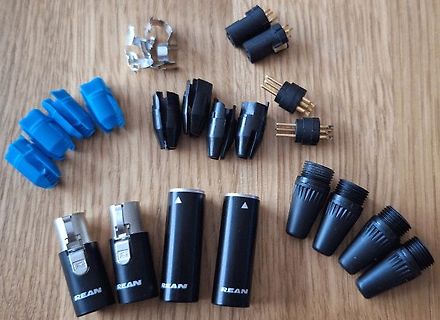 Diverse elektrische Steckverbinder und Klemmen auf Holzuntergrund