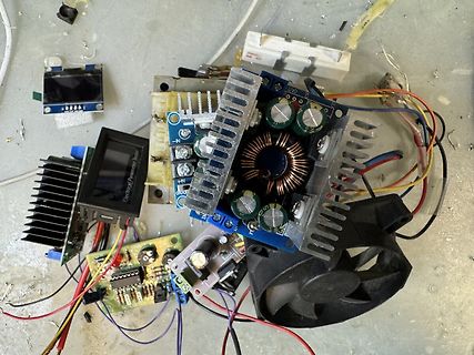 Elektronikbauteile, Platinen und Kühlkörper auf Werkstattuntergrund