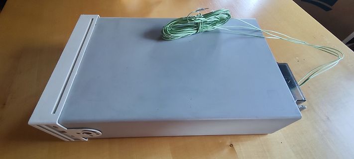 Graues Metallgehäuse mit grünen Kabeln