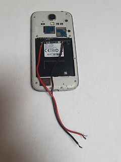 Geöffnetes Smartphone mit freigelegtem Akku und Kabeln
