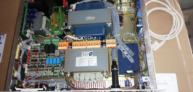 Innenansicht eines elektronischen Geräts mit Transformator und Platinen