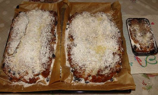 Zwei mit Puderzucker bestäubte Gebäckstücke auf Backpapier