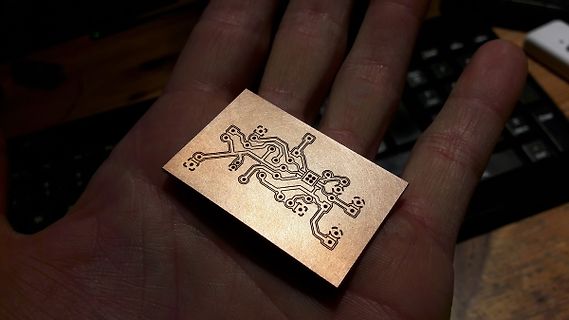 Kleine geätzte Kupferplatine in einer Hand