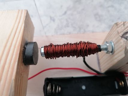 Spule auf Achse zwischen Holzblöcken mit Batteriefach