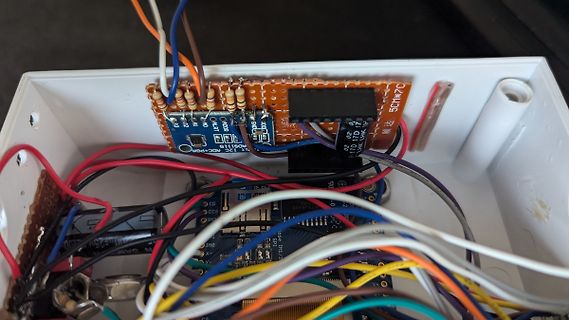 Elektronikaufbau in einem weißen Gehäuse mit Leiterplatten und Kabeln