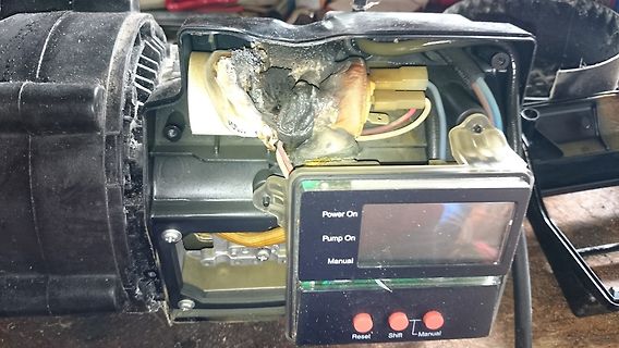 Geöffnetes Gerät mit verschmorten Bauteilen und Display