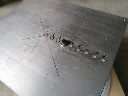 Metallplatte mit markierten Bohrungen und Nummern