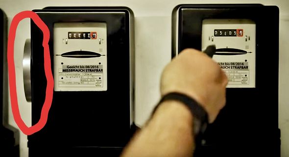 Zwei Stromzähler mit Hand im Vordergrund