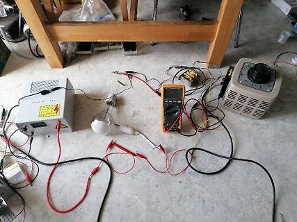 Elektrischer Versuchsaufbau mit Netzteil, Multimeter und Glühlampe
