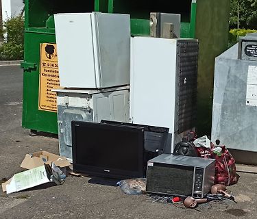 Elektroschrott vor einem Container