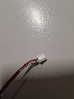 Weißer Stecker mit roten und schwarzen Kabeln