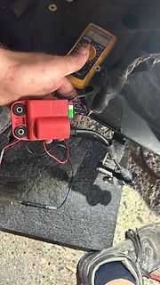 Multimeter und rote Elektronikkomponente mit Kabeln