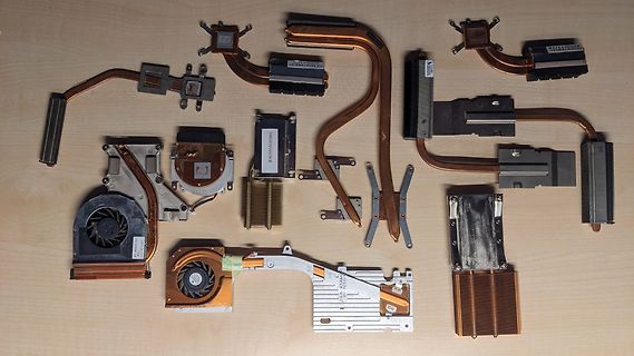 Diverse Laptop-Kühlkörper und Lüfter auf Holzuntergrund