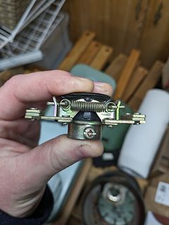Hand hält ein mechanisches Bauteil mit Feder