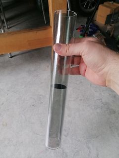 Hand hält ein Glaszylinder